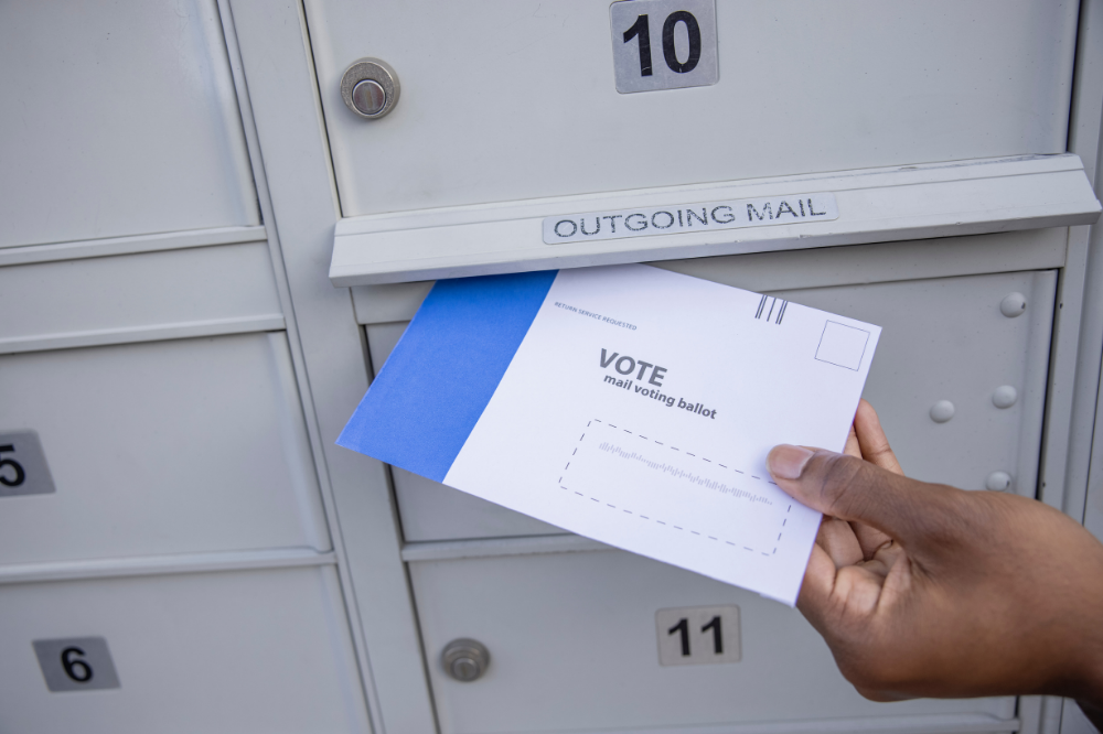 a ballot being delivered into a mailbox