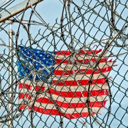 Tattered Flag Behind Barbed Wire