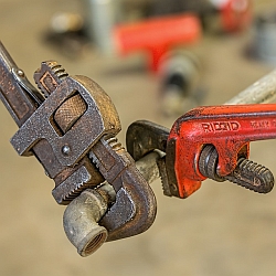 Wrenches Twisting a Pipe